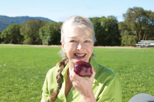 Woman eating an apple with dental implants Scottsdale, AZ